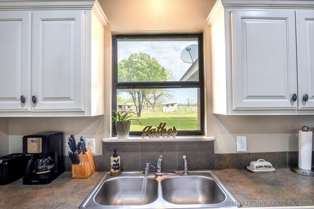 3745 E 420th Rd, Adair, OK 74330 - kitchen featuring dark countertops, a sink, and white cabinetry
