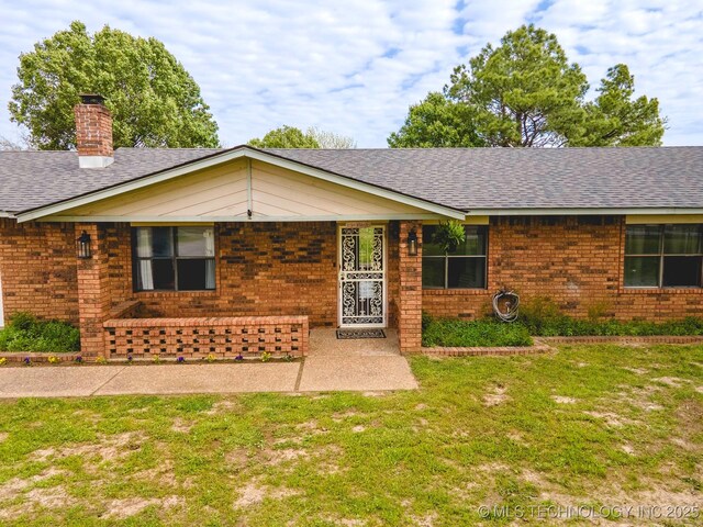 3745 E 420th Rd, Adair, OK 74330 - ranch-style home with brick siding, roof with shingles, a chimney, and a front yard