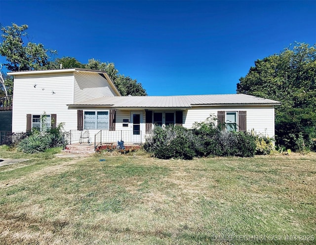 tri-level home featuring a front lawn, metal roof, and covered porch