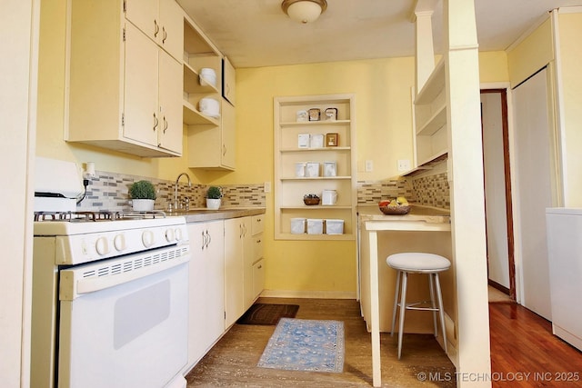 kitchen with open shelves, white gas range oven, dark wood-type flooring, and a sink