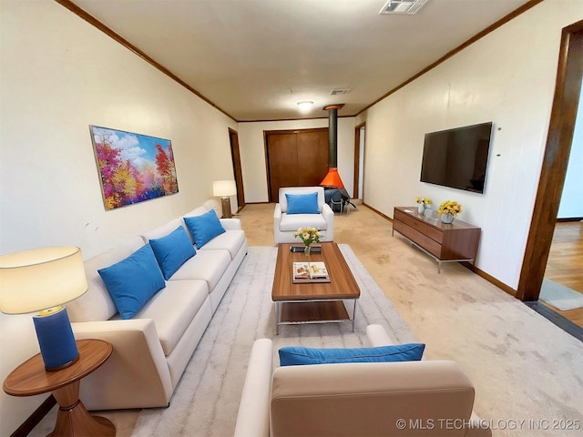 living area with crown molding, a wood stove, light colored carpet, baseboards, and visible vents