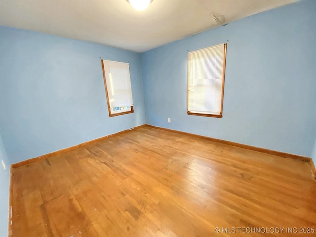 unfurnished room featuring baseboards and wood finished floors