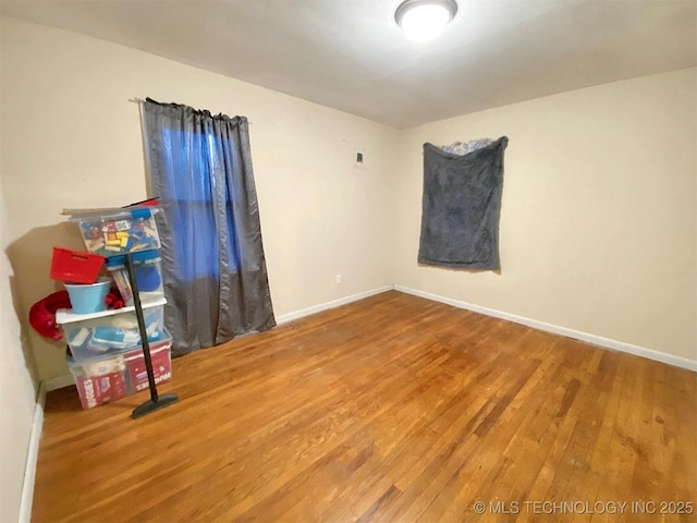 unfurnished room with baseboards and wood finished floors