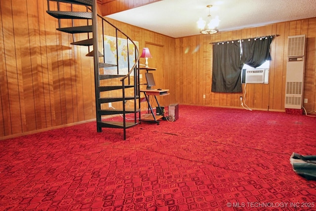carpeted living area featuring stairway, wood walls, and cooling unit