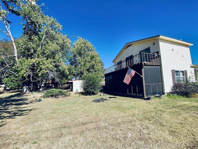 view of home's exterior featuring a wooden deck and a yard