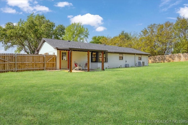 back of house featuring central air condition unit, a lawn, and a fenced backyard