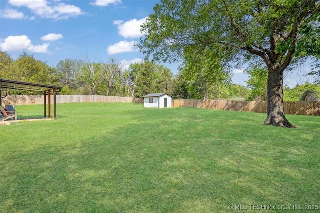 view of yard featuring a fenced backyard, an outdoor structure, and a storage shed