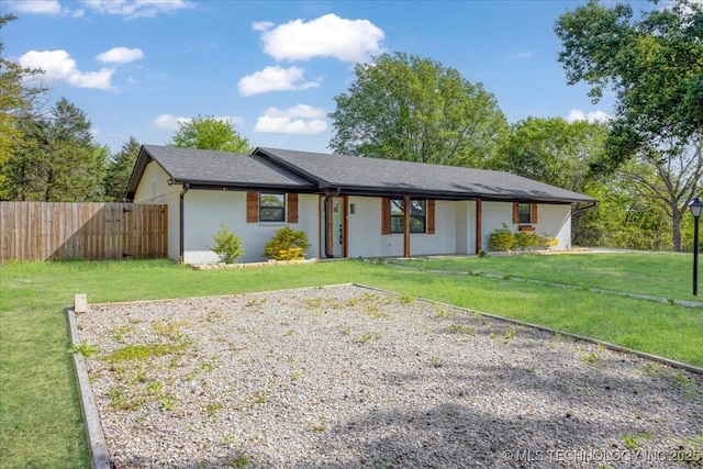 ranch-style home with a front lawn and fence