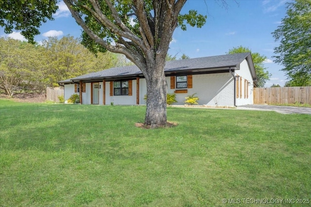 ranch-style house featuring fence, a front lawn, and brick siding