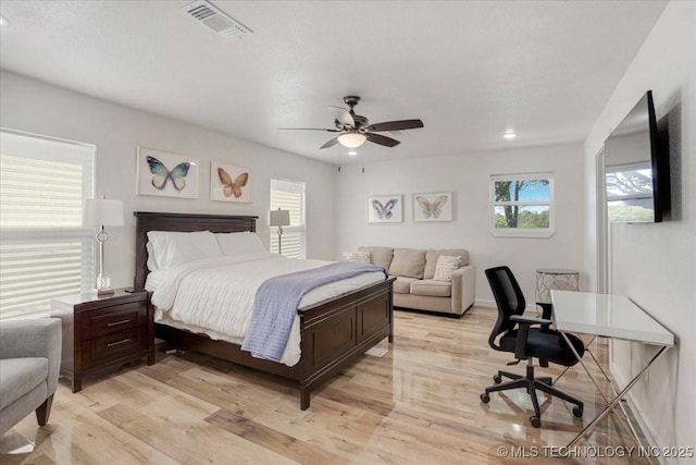 bedroom with light wood-type flooring, visible vents, and ceiling fan