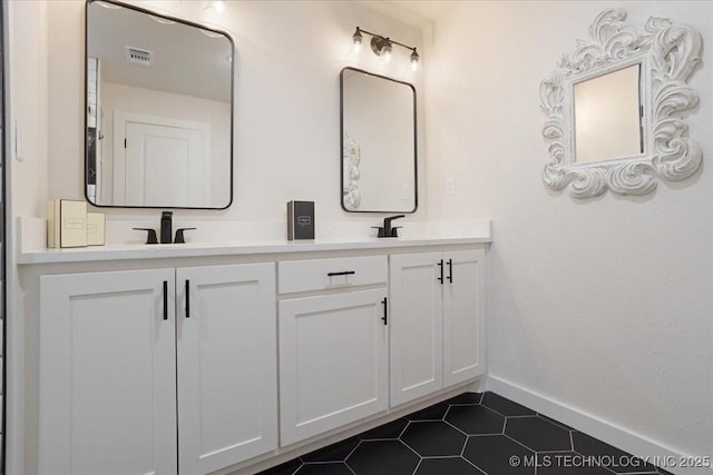 full bathroom with a sink, double vanity, baseboards, tile patterned flooring, and visible vents
