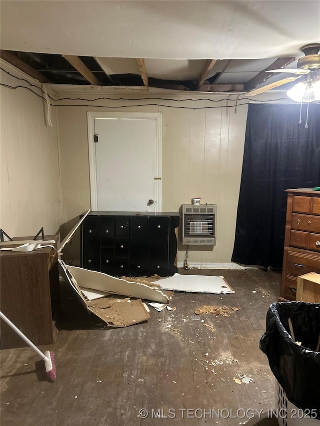 unfinished below grade area featuring heating unit and hardwood / wood-style flooring