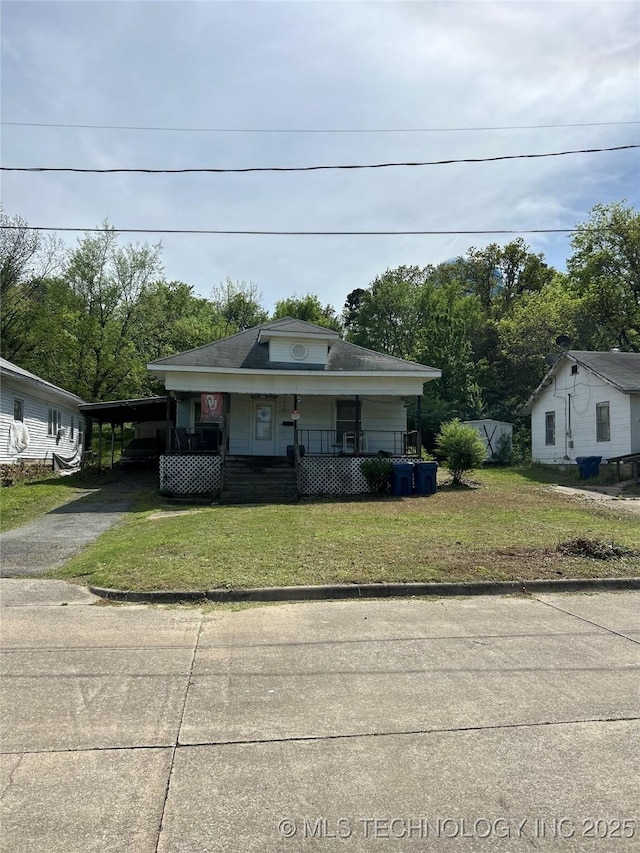 bungalow with a carport, a front lawn, covered porch, and concrete driveway