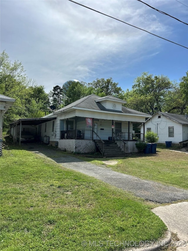 view of front of property with driveway, a front lawn, and covered porch