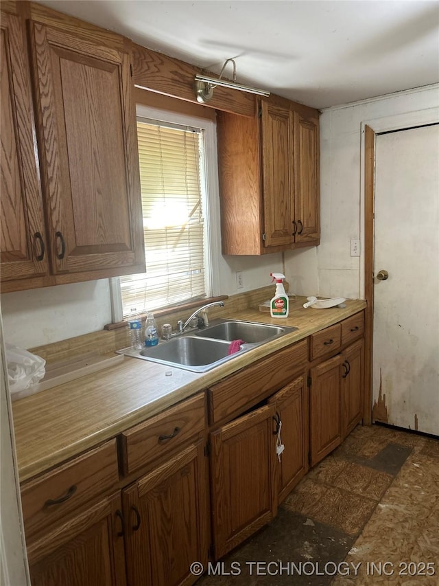 kitchen with light countertops, a sink, and brown cabinets