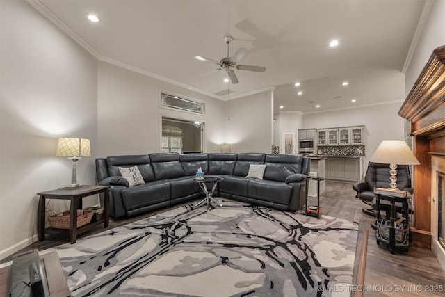 living area with recessed lighting, ornamental molding, visible vents, ceiling fan, and wood finished floors
