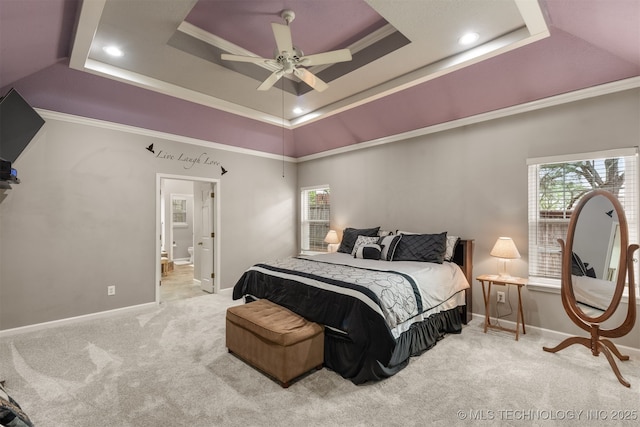 bedroom featuring carpet floors, baseboards, ensuite bathroom, recessed lighting, and a tray ceiling
