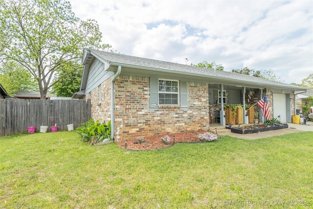 view of front facade with fence, an attached garage, brick siding, and a front yard