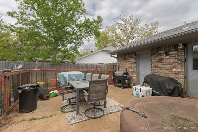 view of patio featuring grilling area, a fenced backyard, and outdoor dining area
