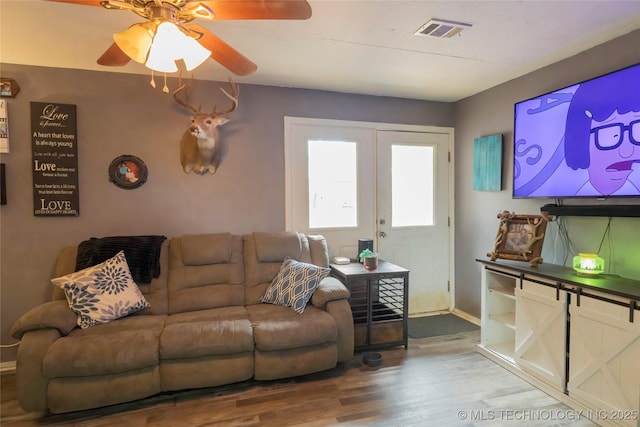 living room featuring french doors, baseboards, visible vents, wood finished floors, and ceiling fan