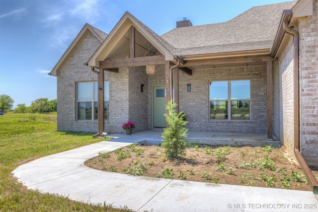 18576 N Jamestown Ave, Skiatook, OK 74070 - view of front facade with a chimney, brick siding, a shingled roof, a front yard, and a porch