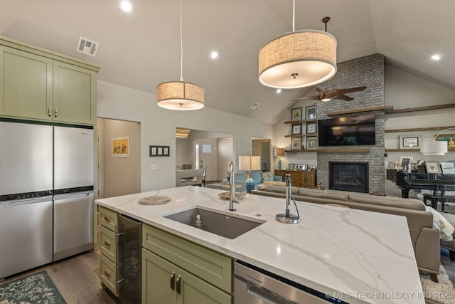 18576 N Jamestown Ave, Skiatook, OK 74070 - kitchen with a sink, visible vents, open floor plan, green cabinets, and appliances with stainless steel finishes