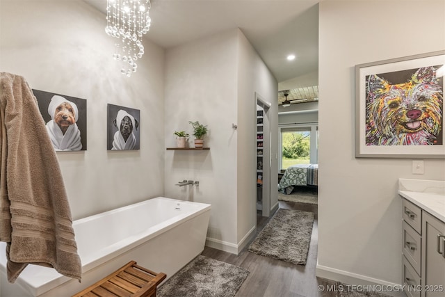 18576 N Jamestown Ave, Skiatook, OK 74070 - full bathroom featuring wood finished floors, a soaking tub, ensuite bathroom, baseboards, and vanity