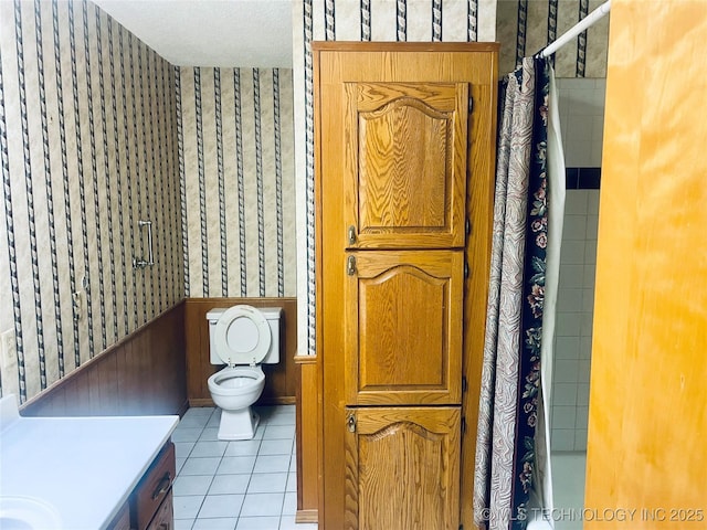 109 Ash Ave, Fort Gibson, OK 74434 - bathroom featuring wallpapered walls, tile patterned flooring, a wainscoted wall, toilet, and a shower with curtain