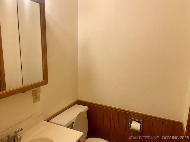 109 Ash Ave, Fort Gibson, OK 74434 - half bath featuring wainscoting, toilet, wood walls, and vanity