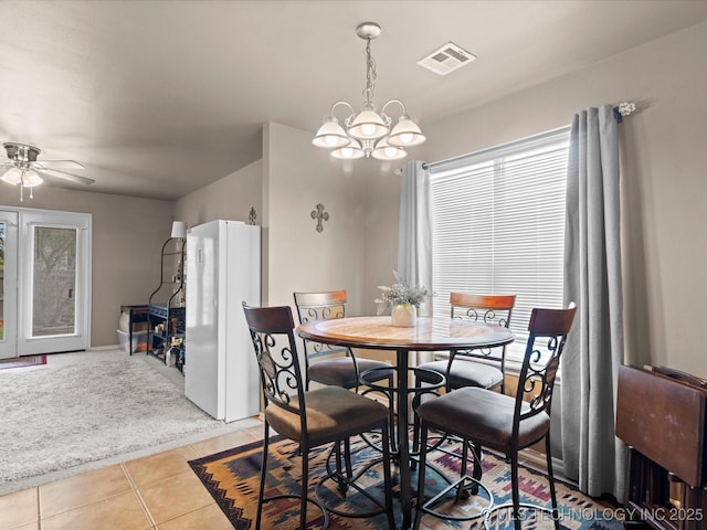 dining room with visible vents, light tile patterned floors, and ceiling fan with notable chandelier