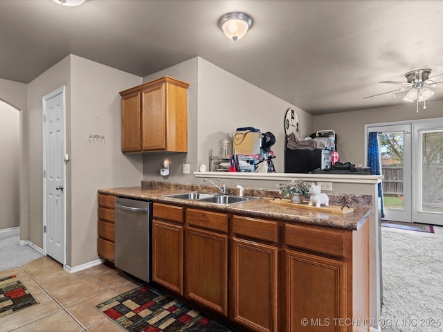 kitchen with brown cabinets, a sink, a ceiling fan, a peninsula, and stainless steel dishwasher