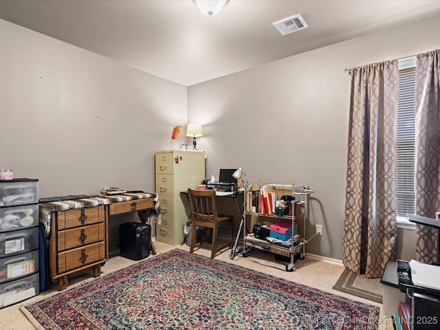 home office with visible vents, baseboards, and light carpet