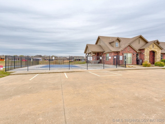view of community featuring uncovered parking and fence