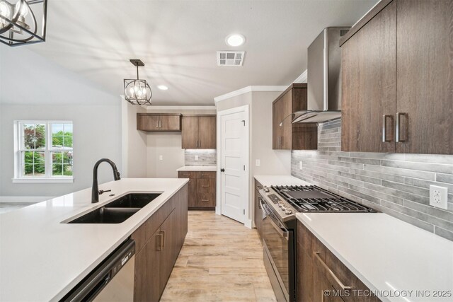 919 E 11th St, Claremore, OK 74017 - kitchen with wall chimney range hood, stainless steel appliances, a sink, recessed lighting, and light countertops