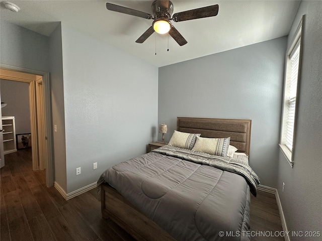 bedroom featuring wood finished floors, baseboards, and multiple windows