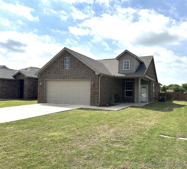 view of front of property with a front lawn, driveway, fence, brick siding, and a garage