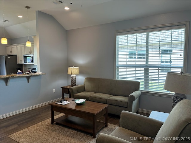 living area with lofted ceiling, a healthy amount of sunlight, dark wood-type flooring, and baseboards