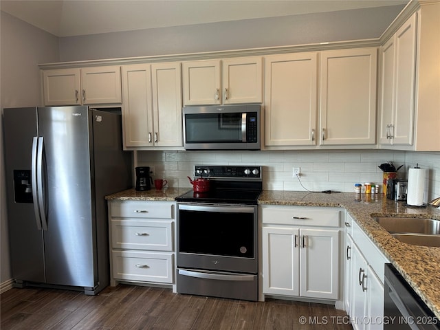 kitchen with dark wood-type flooring, backsplash, appliances with stainless steel finishes, and a sink