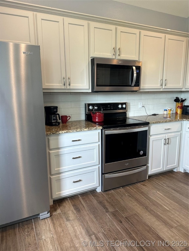 kitchen with light stone counters, backsplash, dark wood-style flooring, and stainless steel appliances