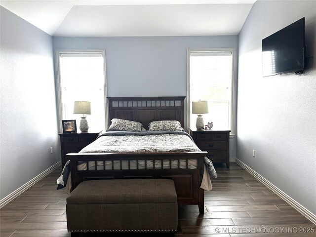 bedroom with dark wood finished floors and baseboards