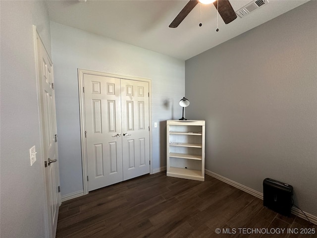 bedroom featuring dark wood finished floors, baseboards, visible vents, a closet, and ceiling fan