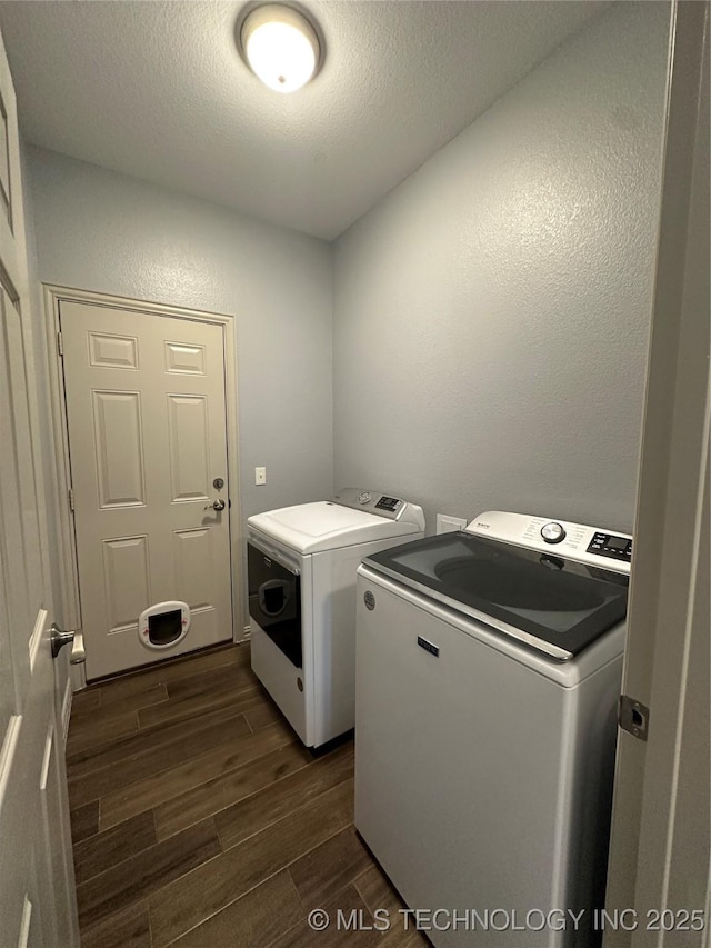 washroom featuring dark wood finished floors, washer and clothes dryer, laundry area, a textured wall, and a textured ceiling
