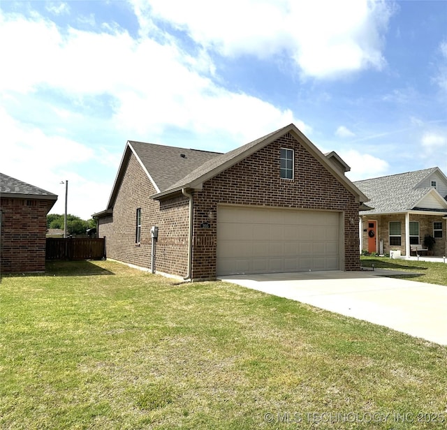 view of side of home featuring fence, a yard, concrete driveway, brick siding, and a garage