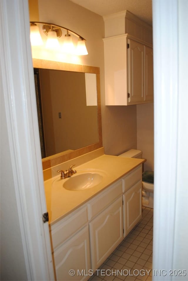 bathroom featuring tile patterned floors, vanity, and toilet