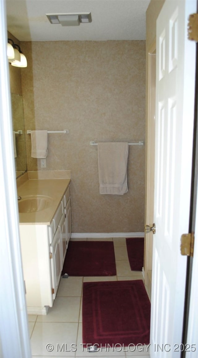 bathroom featuring visible vents, tile patterned floors, baseboards, and vanity