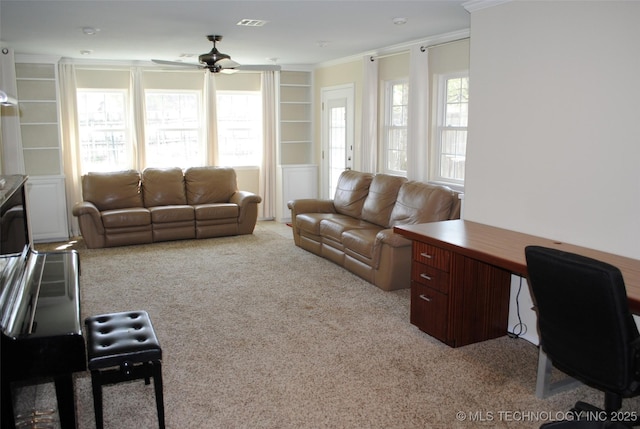 carpeted living room with ornamental molding, built in shelves, and ceiling fan
