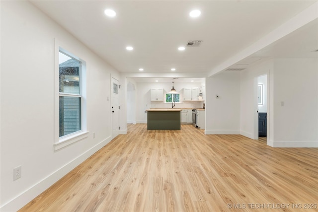 unfurnished living room featuring visible vents, light wood-style flooring, baseboards, and recessed lighting