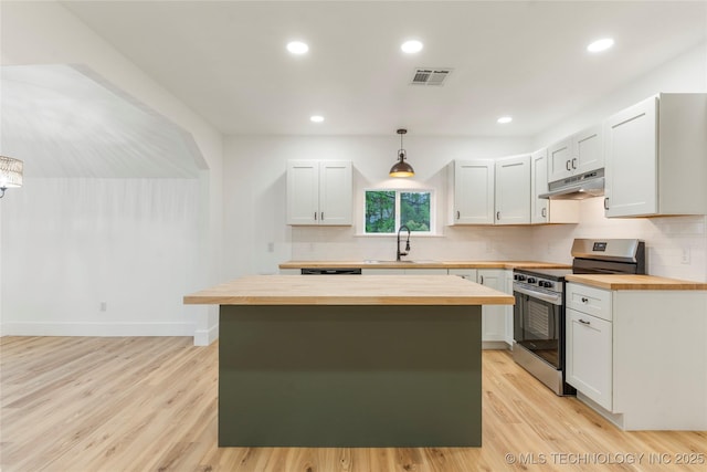 kitchen with under cabinet range hood, stainless steel electric range oven, visible vents, a sink, and wood counters