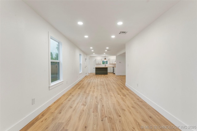 unfurnished living room with baseboards, light wood-style floors, visible vents, and recessed lighting