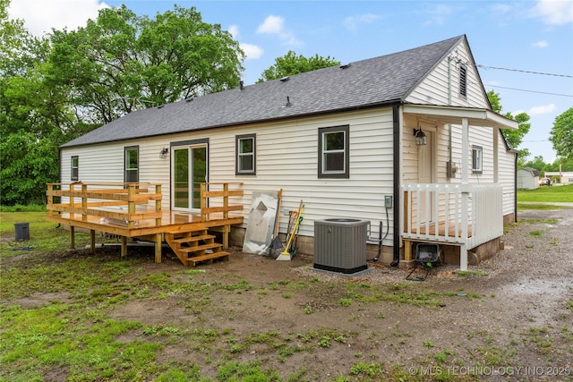 back of house featuring a shingled roof, central AC unit, and a deck